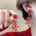 Detailed macro shot of elegant red rhinestone earrings featuring Chinese characters Xi and Le - Joy Happiness Character Drop (7#) / Red
