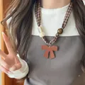 Folk style plaid fabric necklace with brown leather bow pendant and acrylic beads. - Necklace Style 18 / Brown