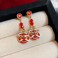 Nahaufnahme festlicher roter chinesischer Löwentanz-Ohrringe in einer Schmuckschatulle - 醒狮珠饰款式(款式二)