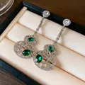 Detailed macro shot of long hollow gourd earrings featuring emerald stones and sparkling crystals - Hollow Hulu (HE22509) / Silver Plated Green