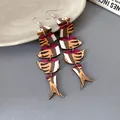 Vista dettagliata di orecchini etnici in legno con stampa a pesce rosso e giunture. - Stile a Gancio / Giallo