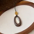 Dettaglio ravvicinato di una collana vintage con pendente ovale in resina e ambra - Ciondolo Ovale a Goccia Grande (6098608443395)
