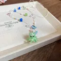 Nahaufnahme einer bunten Perlenkette mit einem süßen grünen Oktopus-Anhänger - Stil 26 Hellgrüner Oktopus Glas Handgefertigte Perle