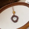 Dettaglio di una collana in resina stile etnico retrò con un ciondolo marrone unico. - Ciondolo Quadrato Irregolare (6098608443397)