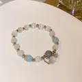 Detailed close-up of a handmade beaded bracelet with white cat's eye and blue stones - Style 17 Blue Beads (Rhinestone Charm)