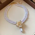 Elegant vintage double-strand pearl necklace with golden rose floral pendant and teardrop pearl. - Double Layer Camellia Artificial Pearl Necklace / Gold-White