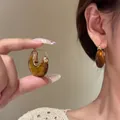 Französische Vintage-Creolen aus Bernsteinharz mit geometrischem Design am Ohr - Goldbraun