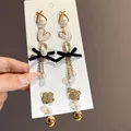Primo piano di una collezione di orecchini eleganti con perle e fiocchi neri - 8# Perno in argento - Oro