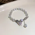 Elegant grey cat-eye beaded bracelet featuring a sparkling rhinestone butterfly charm pendant - Rhinestone Butterfly Cat's Eye Bracelet / White