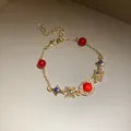 Elegant vintage style gold bracelet featuring red beads and blue sparkling star charms - Bracelet (28#) / Gold-Red