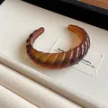 Statement amber resin open bangle with twisted geometric texture and marbled pattern finish - Style 47