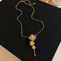 Close-up detail of a gold plated necklace with three filigree flower pendants. - 1# Flower Tassel Style / Gold
