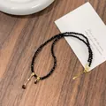 Close-up of faceted black crystal beads and gold teardrop pendant on necklace detail - Teardrop Pendant Style (WN801) / Black