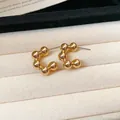 Close-up of minimalist gold-plated C-shaped bead earrings on jewelry tray - Style 9 / Small / Gold