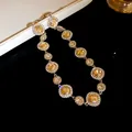 Elegante collana dorata con ciondoli in cristallo champagne e dettagli con strass - Collana / Oro - Champagne