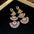 High-detail macro view of glamorous triple-tiered fan drop earrings with purple crystals - Earrings / Blue and Purple