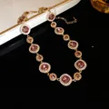 Primo piano dettagliato della collana con cristalli rosa e diamanti su una raffinata catena dorata - Collana / Oro-Viola