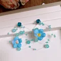 Dettaglio di orecchini a fiore in tessuto blu con cristalli e perline su vassoio - Stile 18 (Perno in Argento)