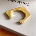 Gros plan d'un bracelet jonc ouvert géométrique irrégulier fini en or. - 不规则U型款式(10#)