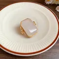 Dettaglio di un anello minimalista dorato con una grande pietra naturale rettangolare - Anello in Pietra Naturale Quadrata (WR237) / Oro/Bianco