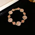 Elegante bracciale a maglie placcato oro con cristalli rosa rotondi e strass lucidi - Bracciale / Oro-Rosa
