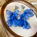 Dettaglio ravvicinato di orecchini a fiore in tessuto blu con eleganti perle e perline. - Stile 48 (Perno in Argento)