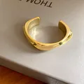 Vue macro d'un bracelet manchette doré poli à géométrie irrégulière pour femmes élégantes. - 波浪几何款式(8#)