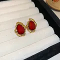 Elegant vintage gold stud earrings with faceted red glass stones in jewelry box. - Vintage Irregular Ripple Studs (25#) / Red