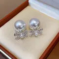 Elegant French vintage earrings featuring large pearls and diamond-studded bow details. - Silver