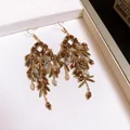 Vintage gold-toned bohemian dangle earrings with multi-layered beaded tassels and tubes - Gold/Brown
