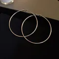 Primer plano detallado de pendientes de aro plateados extra grandes sobre terciopelo negro - Aro Grande Minimalista (26) / Plata-Diámetro 60mm