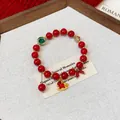 Detailed view of red beaded bracelet with golden horse charm on elegant prop background - Style 4 / Red
