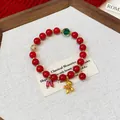 Close-up detail of red beaded bracelet featuring a golden horse charm and green gem - Style 5 / Red