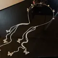 Vue détaillée d'un élégant serre-tête papillon doré avec perles et longues chaînes - Papillon Long Gland Perle (HH1959)