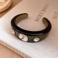 Close-up of vintage resin cuff bracelet with gradient finish and inlaid crystals - Black Transparent