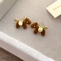 Detalle de unos pendientes de poni flocados en marrón con detalles dorados y aguja de plata. - Caballo de Carreras Flocado Marrón (56#)