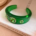 Detailed macro shot of a green resin cuff bracelet with sparkling crystal accents - Green