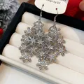 Détail de boucles d'oreilles flocon de neige en argent avec strass scintillants - Crochet d'Oreille Style Flocon de Neige / Argent