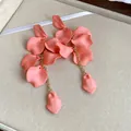 Detail view of Bohemian coral pink matte petal tassel earrings with gold chains - Pink