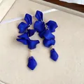 Detailed close-up of matte blue petal tassel earrings with elegant Bohemian design elements. - Blue