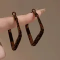 Close-up of retro leopard print fabric hoop earrings with a unique geometric rhombus shape - Rhombus Leopard Earrings / Brown