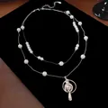 Detail view of the Saturn pearl double-layer necklace on black velvet background - Double Layer Saturn Sweater Chain (Silver) / White (6-8mm Pearl)