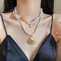 Close-up detail of a double-layer pearl necklace set with elegant golden shell pendants - Two-Piece Set / Gold/White/Yellow