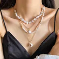 Detailed view of a four-layer ocean style necklace featuring pearls and shell pendants - Four-Piece Set / Gold & White