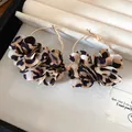 Detailed view of the leopard print fabric flower charms on golden hoop earrings - Ear Hoop Style (Gold Leopard Coffee)