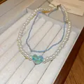 Elegant double-layered necklace featuring white pearls and a blue gradient heart pendant - Blue White Heart