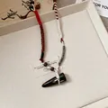 Close-up of a handmade ethnic woven necklace featuring a dark toggle-shaped pendant - 74# Necklace - White - Brown - Red