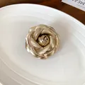 Macro view of an elegant handmade gold leather rose brooch with a metallic finish - Gold