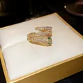 Close-up of a gold-plated snake-shaped open ring with cubic zirconia on a jewelry box. - Adjustable Open / Gold