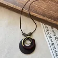 Vintage Zen-style necklace featuring a dark wood circular pendant and antiqued brass rings. - Necklace #12 - Brown - Round